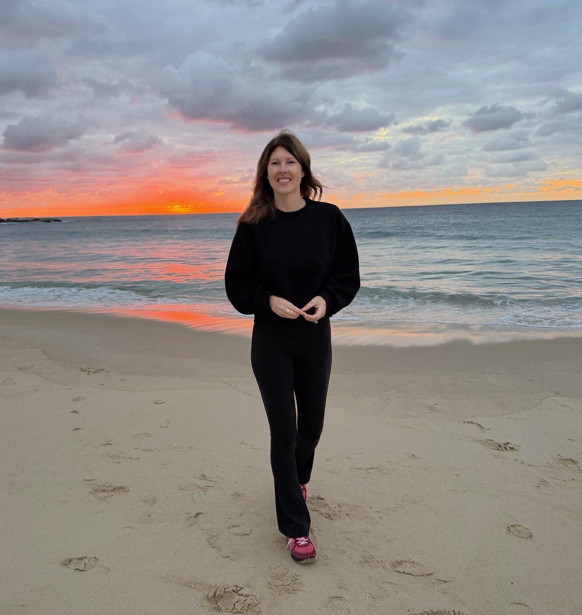 Eliza Lin, who founded Oyster, smiling on a beach at sunrise